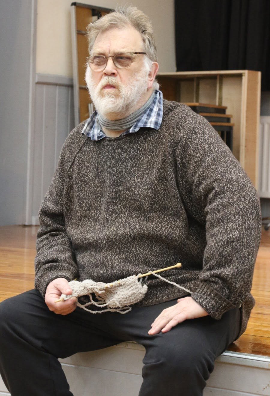 An As You Like It performer seated with a script