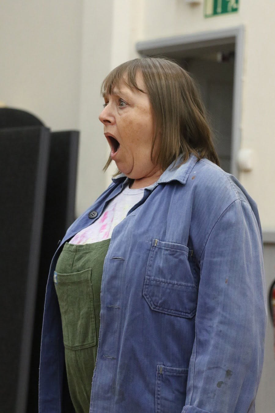 A company member working a scene in a blue jacket