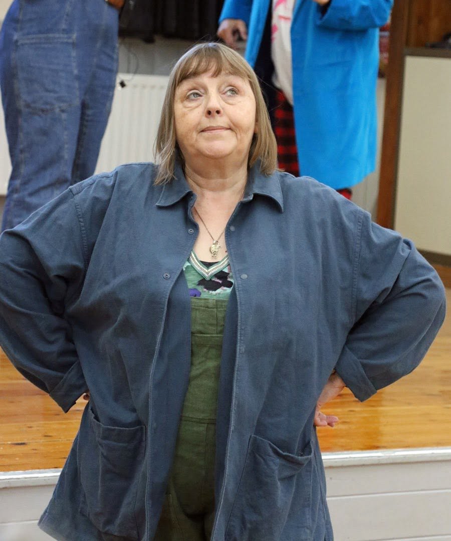A company member rehearsing with hands on hips